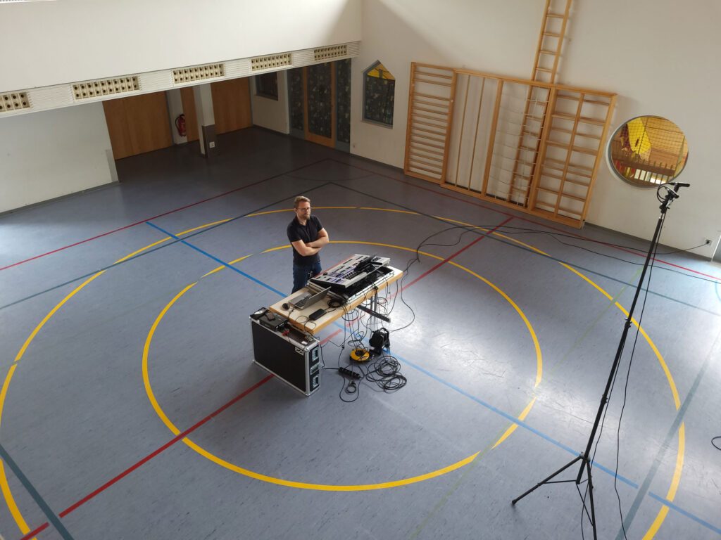 Aufbau von Mischpult und Mikrofonstativen in einer Halle